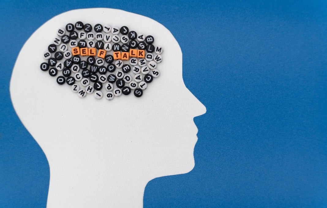 paper-cut human head, a vibrant assortment of letters, and the word 'Self-Talk' - symbolizing internal dialogue and the power of thought