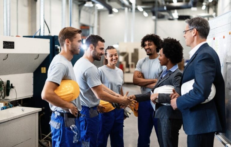 manager greeting workers in a factory.