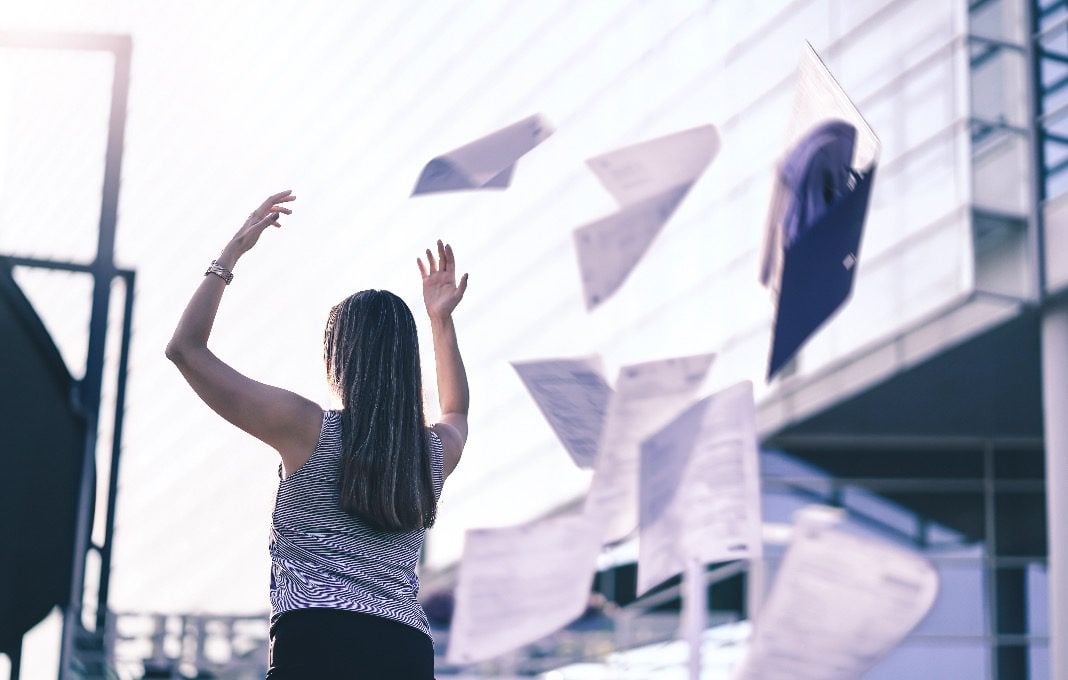 woman quitting, throwing papers in the air