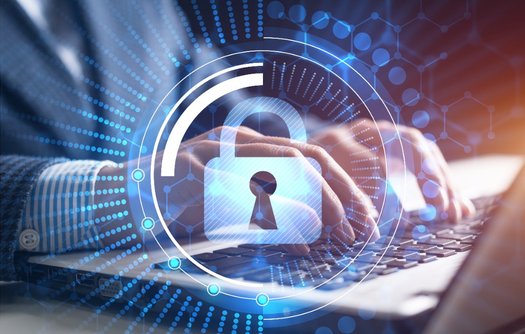 Image of lock overlayed man typing on laptop