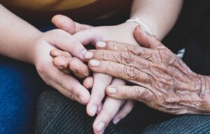 Young grandchildren's holding older grandmother hands
