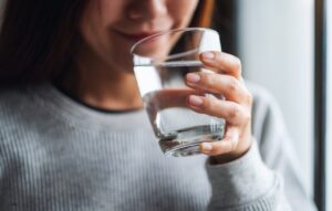 Closeup image of a woman holding a glass of water to drink