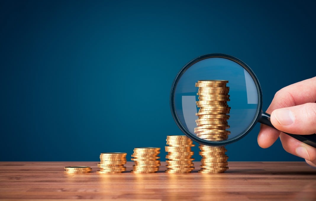 Magnifying glass over stack of coins