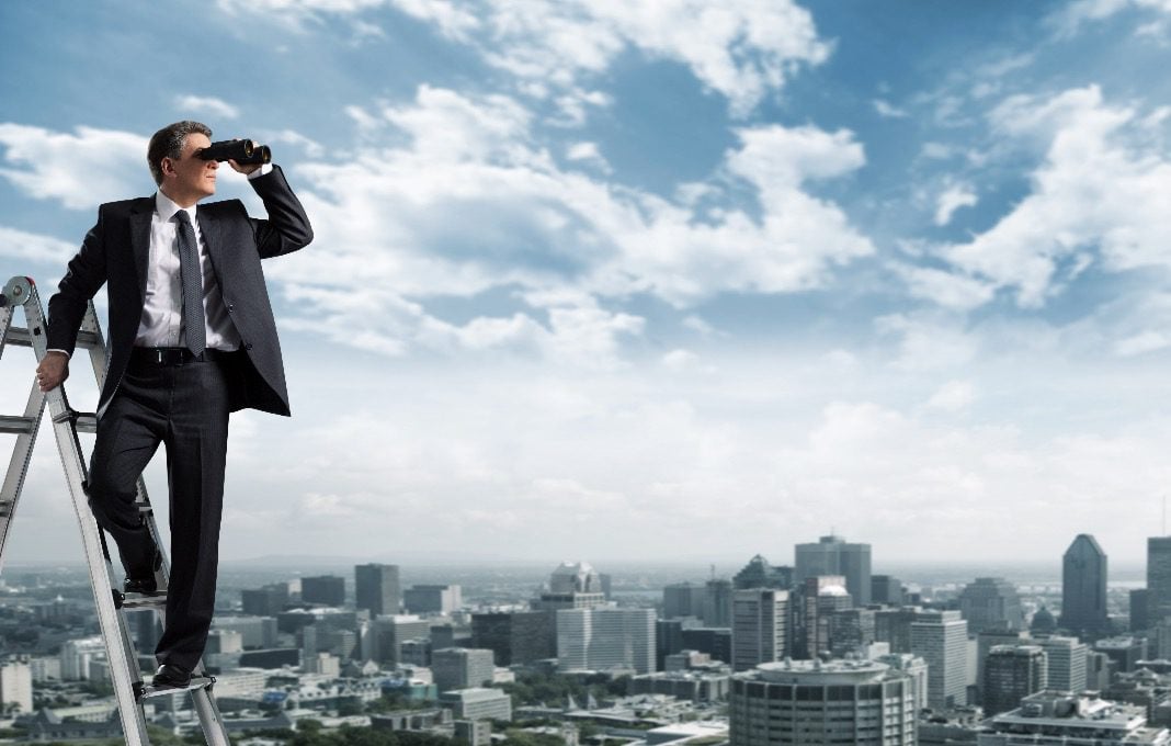 Man on ladder looking out with binoculars
