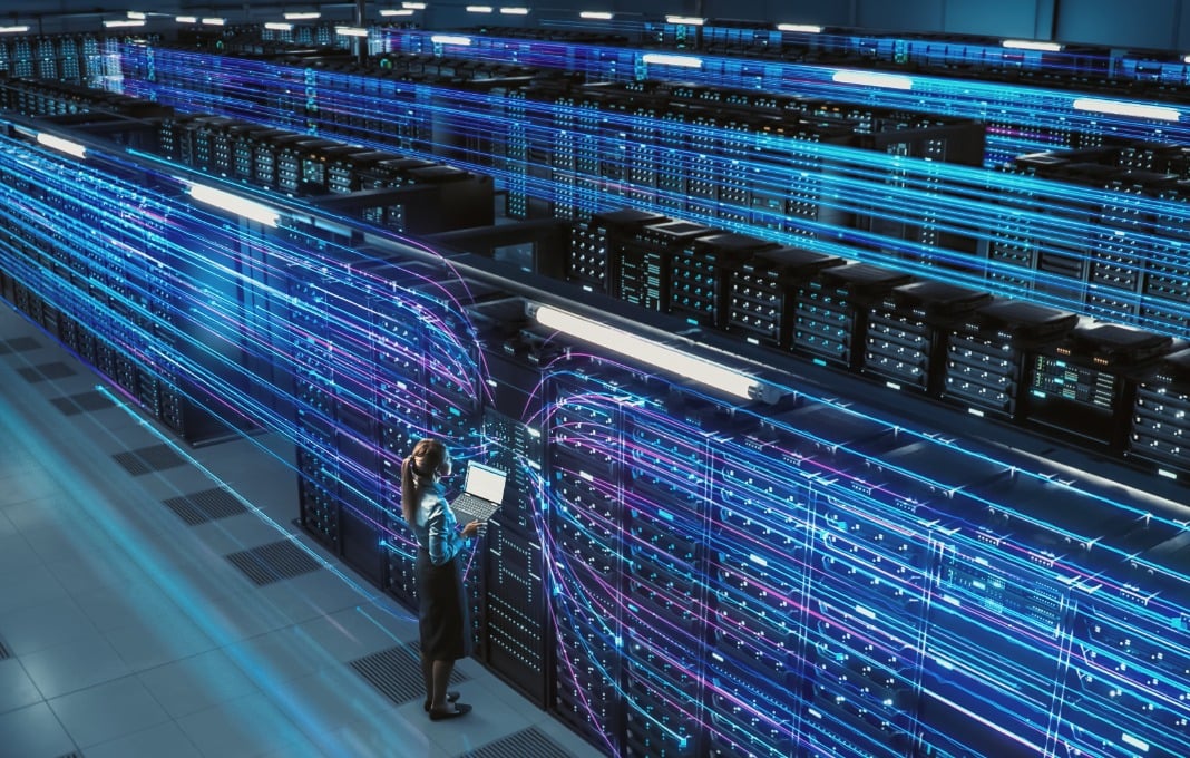 Big Data Center Female Chief Technology Officer Using Laptop Standing In Warehouse