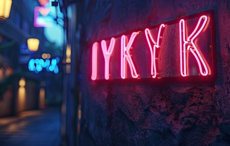 IYKYK in neon on the side of the building